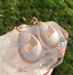 These holographic Teardrop geode earrings made from resin shift from clear gold to a beautiful sparkly rainbow. They are lightweight and won't bother your ears. Please be aware that resin is heat resistant up to 135 degrees. Wearing these earrings in extremely hot temperatures will cause them to be pliable. If this happens, simply place in a cooler location. I am not responsible for any damaged earrings due to extreme heat. Made by Katie Glover Resin Art by Katie 2020 Contact me on my Instagram Clear Resin Jewelry With Ear Wire, Sparkling Dangle Teardrop Earrings Gift, Hypoallergenic Resin Jewelry For Parties, Sparkling Teardrop Dangle Earrings As Gift, Teardrop Sparkling Jewelry For Gift, Iridescent Sparkling Jewelry As Gift, Sparkling Iridescent Jewelry As Gift, Iridescent Sparkling Jewelry Gift, Sparkling Iridescent Jewelry For Gifts