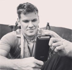 a man sitting down looking at his cell phone