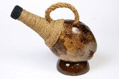 a brown and black vase with a rope wrapped around it