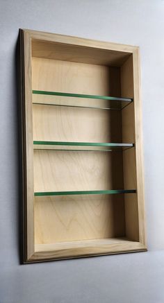 an empty wooden box with glass shelves on the wall