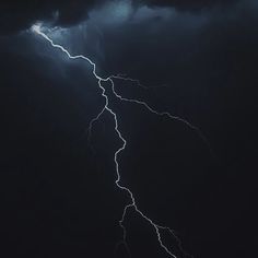 a lightning bolt is seen in the dark sky