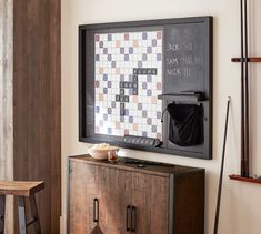 a blackboard mounted to the wall above a wooden cabinet