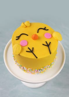 a yellow cake decorated with sprinkles and eyes