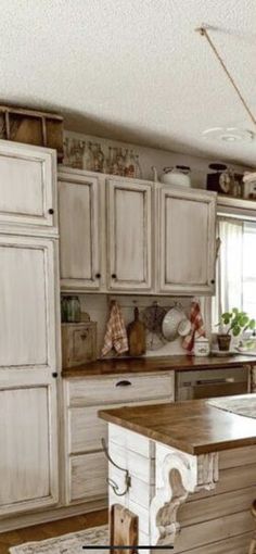 a kitchen with an island in the middle of it and lots of cupboards on both sides