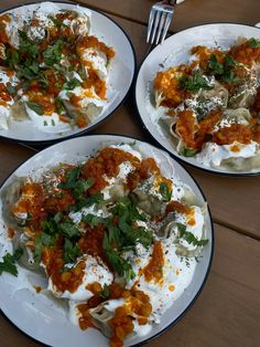 two white plates filled with food on top of a wooden table