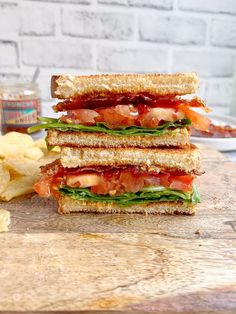 two sandwiches stacked on top of each other next to chips