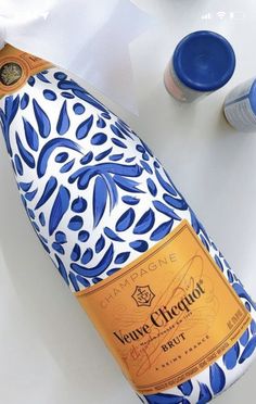 a blue and white bottle sitting on top of a table next to some bottles of wine