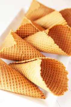 four waffle cones sitting on top of a white plate