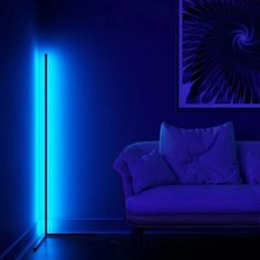 a living room with a couch and blue light in the corner, it appears to be dark