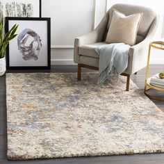 a living room area with a chair, rug and pictures on the wall in front of it