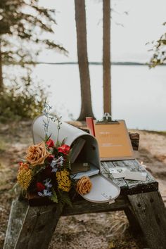 a mailbox with flowers on it sitting on a wooden bench