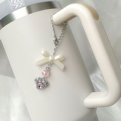 a close up of a cup with a chain attached to it and a cross charm