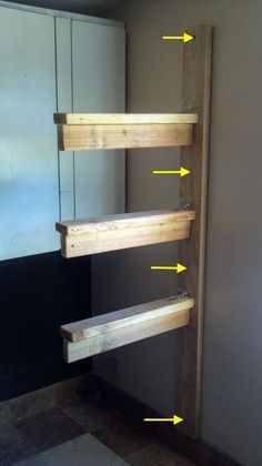 the shelves are made out of wood and have yellow arrows pointing to them