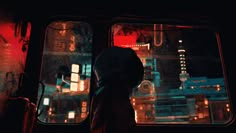 the silhouette of a person standing in front of a window at night with city lights