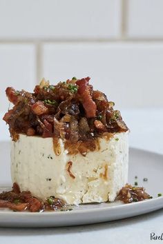 a piece of cake on a white plate with bacon toppings and other ingredients around it