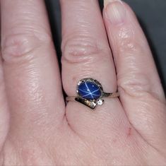 a woman's hand with a ring on it and a blue stone in the middle