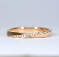 a gold wedding band with diamonds on it