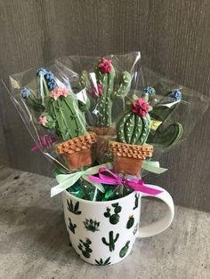 a coffee mug filled with cactus plants and waffles in plastic wrapped around it