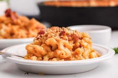 a white bowl filled with macaroni and cheese on top of a table next to other dishes