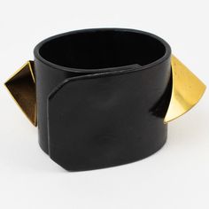 Stylish Givenchy Paris signed belt bracelet, designed by Riccardo Tisci for his 2011 Obsedia Collection. It features an oversized band shape, in black leather ornate with brutalist geometric gilded brass dimensional elements. Snap closing clasp. Engraved Givenchy signature on the inside. Measurements: The bracelet's total length is 9.25 in long (23.5 cm) - The width is 2 in wide (5.1 cm) - The bracelet will best fit a Small size wrist with a maximum of 6.88 in circumference (17.5 cm).   Please s Modern Leather Bracelet For Party, Modern Leather Bracelet For Parties, Modern Leather Party Bracelet, Adjustable Leather Evening Jewelry, Adjustable Brutalist Metal Bracelets, Adjustable Brutalist Metal Bracelet, Luxury Brutalist Metal Jewelry, Gold Brutalist Hand-cast Jewelry, Black Brutalist Sterling Silver Jewelry