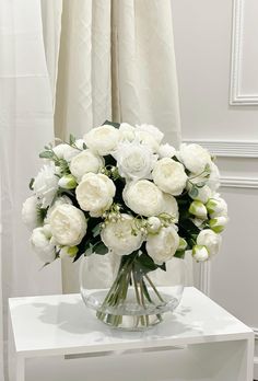 a vase filled with white flowers on top of a table