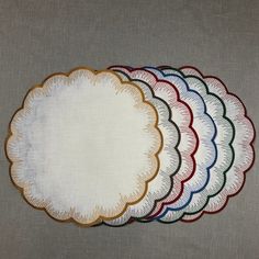 six round placemats with different colors and designs on the top one has a white circle in the middle