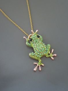 a green frog necklace on a gold chain