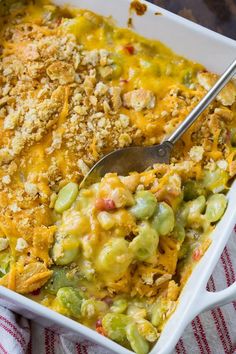 a casserole dish filled with green beans, cheese and bread crumbs