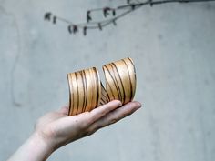 a person holding two wooden rings in their hand