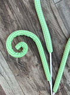 green and white checkered umbrella on wooden floor with string wrapped around it's handle