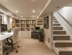 a home office with stairs leading up to the second floor and desks on either side