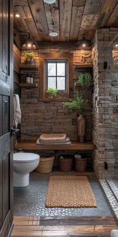 a rustic bathroom with stone walls and wood flooring, along with a toilet in the corner