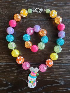 "Rainbow Snowman Chunky Bubblegum Rainbow Bead Necklace & Bracelet This Rainbow Snowman themed necklace will bring a smile to your little one's face! Great accessory to put with any color of the rainbow. This will make a lovely party favor, holiday party accessory or gift for birthdays or holidays. Made with primarily 20mm bubblegum beads in shades of pink, orange, yellow, green, blue and purple. The necklace measures approximately 11\" when toggled around neck including the unicorn pendant. Themed Multicolor Beaded Jewelry, Themed Multicolor Round Bead Jewelry, Themed Multicolor Round Beads Jewelry, Whimsical Jewelry With Colorful Beads For Birthday, Whimsical Colorful Beaded Jewelry For Birthday, Themed Beaded Multicolor Jewelry, Novelty Multicolor Necklaces For Birthdays, Multicolor Novelty Necklaces For Birthdays, Fun Large Beaded Jewelry For Gifts