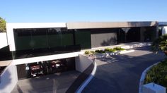 an aerial view of a building with cars parked in the driveway and landscaping around it