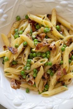 a white bowl filled with pasta and peas