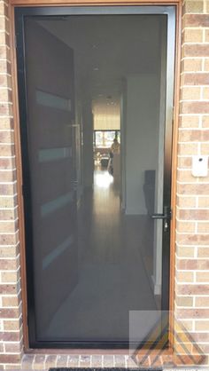 an open door leading to a hallway with brick walls and doors on both sides,