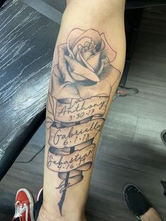 a person with a tattoo on their arm holding a book and a rose in it