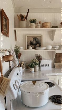 a white stove top oven sitting inside of a kitchen next to a wall mounted shelf filled with pots and pans