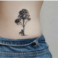 a woman's stomach with a tree tattoo on her side and a man sitting under the tree