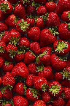 a large group of strawberries are arranged together