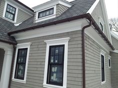 a gray house with white trim and windows