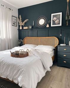 a bed with white sheets and pillows in a room