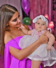 a woman holding a baby in her arms