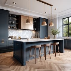 a kitchen with wooden floors and blue cabinets, two stools at the center island