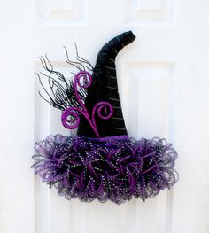 a purple and black witch hat hanging on the front door