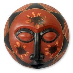 an orange and black mask is shown on a white background with the face painted in red