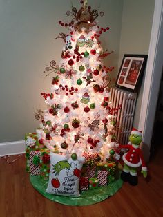 a white christmas tree decorated with candy canes and ornaments is lit up in the corner