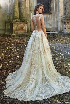 a woman in a wedding dress is looking at the camera and she has her back turned