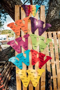 a wooden sign with many different colored fish on it's sides and words written on the side