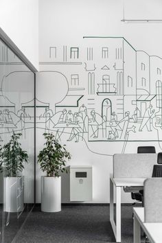 an office area with desks, chairs and a drawing on the wall behind them